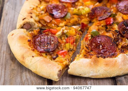 Delicious Baked Salami Pizza Served On Rustic Wooden Table