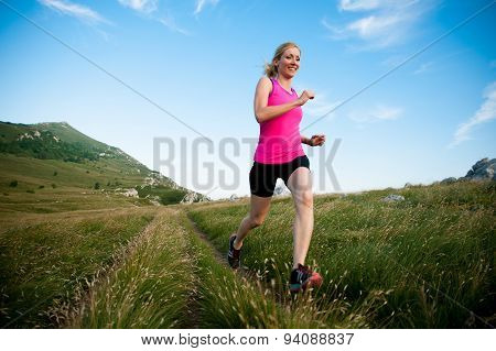 Beautiful Young Woman Runns Cross Country On A Mountian Path At Sunrise
