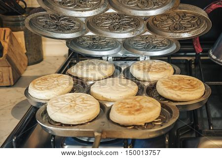 cooking Tigelle in special pan called Tigelliera traditional food Bologna Modena Emilia Romagna