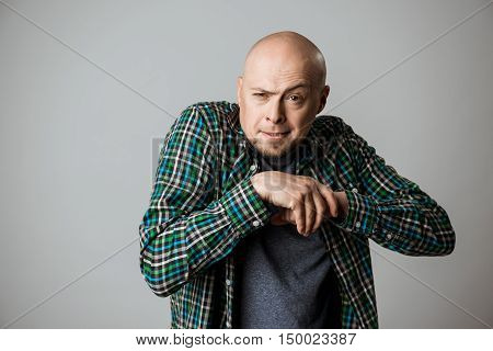 Vicious emotional man in shirt posing over beige background. Copy space.