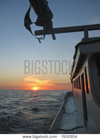 Båd på en tropisk hav med røde solen i ryggen, Togians Island, Sulawesi, Indonesien