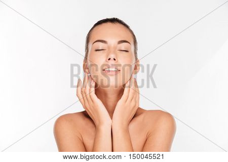 Beauty portrait of a happy woman with fresh skin and eyes closed looking at camera isolated on a white background