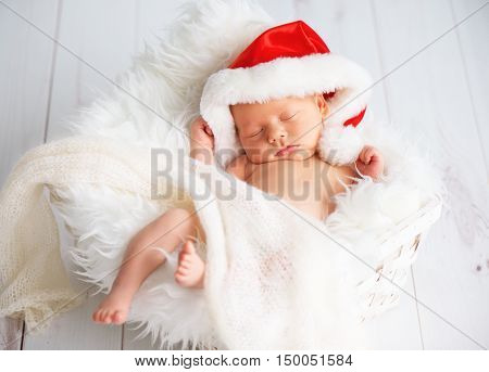 sleeper newborn baby in a Christmas Santa cap