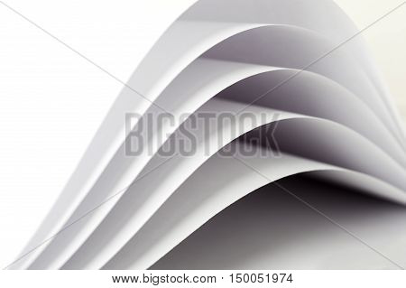 close up of curved sheets of white paper