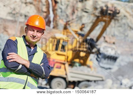 worker in front of heavy excavator and dumper truck