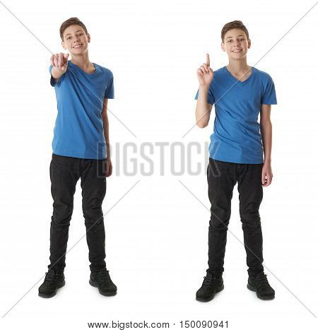 Cute teenager boy in blue T-shirt standing and poinitng forward over white isolated background full body