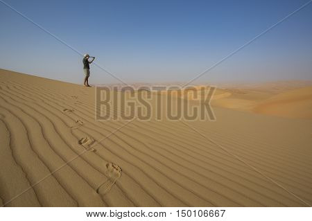 Man looking through spyglass in a desert
