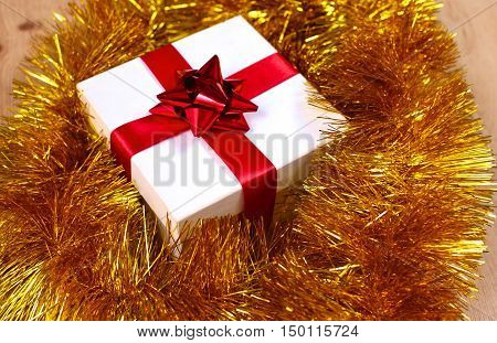 New Year gift on a golden tinsel background boly.