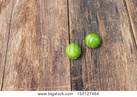 lemon with green on the wooden table top view