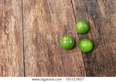 lemon with green on the wooden table top view
