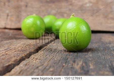 lemon with green closeup Select focus with shallow depth of field on the wooden