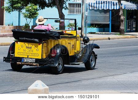 Varadero, Cuba - September 11, 2016:  yellow American Cabriolet Classic Car Dirves in Varadero City, Cuba