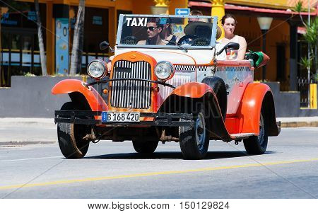 Varadero, Cuba - September 11, 2016:  orange American Cabriolet Classic Car Dirves in Varadero City, Cuba