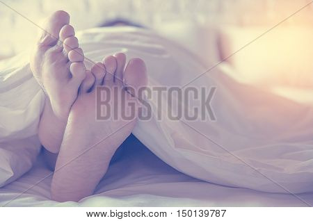 Close up feet of women sleeping women on bed