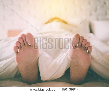 Close up feet of women sleeping women on bed