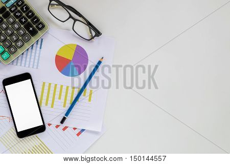 White office desk table with blank screen smartphone chart or analysis chart glasses calculator and pencil. Top view with copy space.Office desk table concept.
