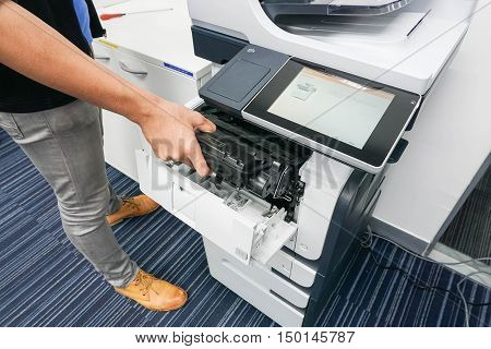 businessman put the ink cartridge into printer