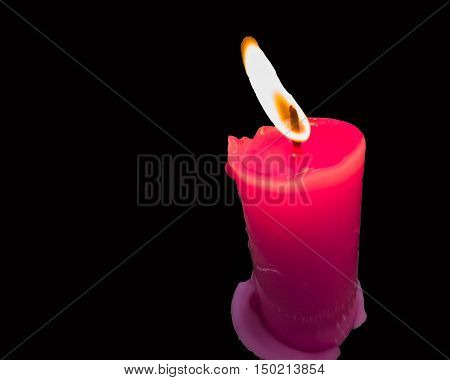 pink burning candle on black background for romantic halloween