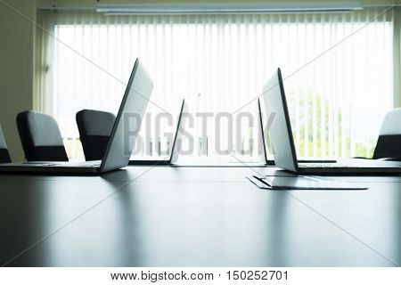 Computer Laptops On Table In Meeting Room.