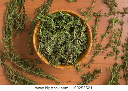 Fresh Thyme into a bowl over a wooden table