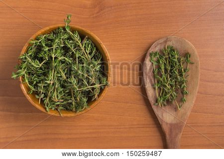 Fresh Thyme into a bowl over a wooden table