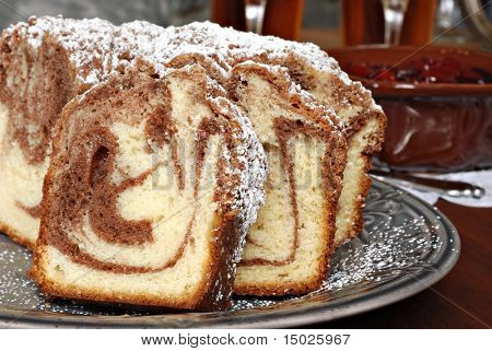 สดอบซินนามอนหมุนเค้กกาแฟ ด้วย topping เชอร์รี่และจานชามในพื้นหลัง  Closeup w