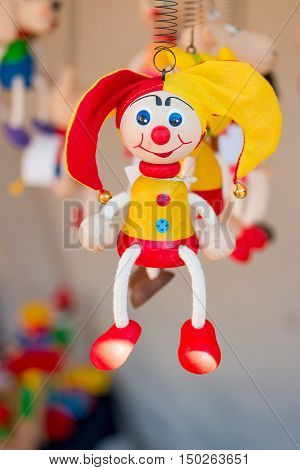 Colorful wooden buffoon figure / toy hanging on the spring