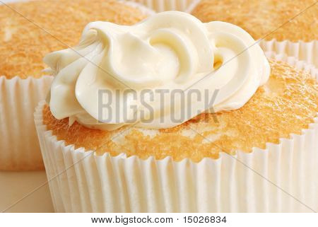 Vers gebakken individu formaat angel food cake met romige swirl vanille glazuur.  Macro met sh