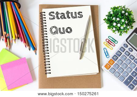 status quo text message on white paper and office supplies, pen, paper note, on white desk , copy space / business concept / view from above, top view