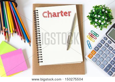charter text message on white paper and office supplies, pen, paper note, on white desk , copy space / business concept / view from above, top view