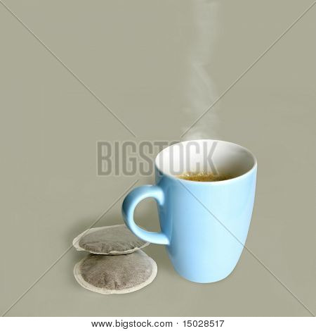 Xícara fumegante de café fresco e almofadas de café ao lado