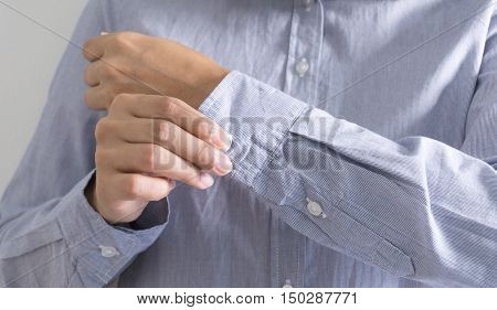 Woman dressing up and fastening buttons on shirt at home.