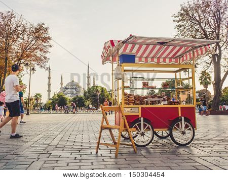 ISTANBUL TURKEY- SEPTEMBER 10-13 2016: Street and city life of Istanbul with snack cart on front and Blue mosque in the background.