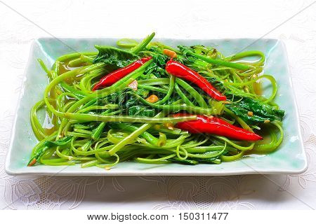 Stir Fried Water Spinachon white plate, Thai food