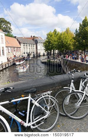 Bruges, Belgium 28 august 2016: ttourist boat in bruges canal near antique bridge on sunny summer day in august