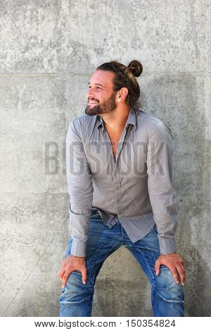 Smiling Man With Beard Leaning Forward With Hands On Knees