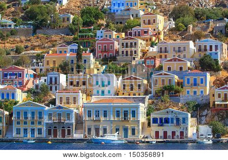 Colorful houses lining harbor at Simi, Greece