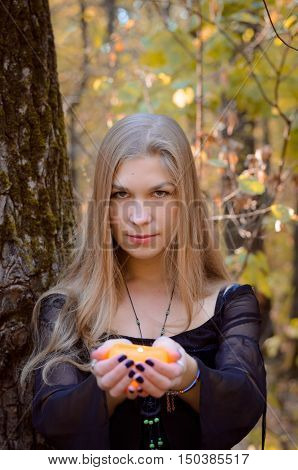 Young Girl In A Fantasy Long Black Dress Posing In An Autumn Forest