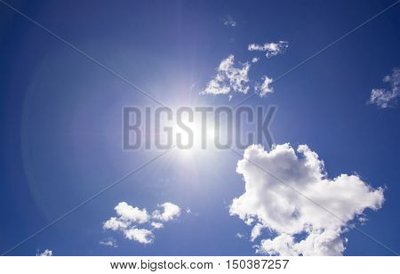The sun shines bright in the daytime in summer. Blue sky and clouds.