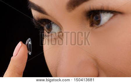 Beauty, vision, eyesight, ophthalmology and people concepts. Closeup of Korean woman putting on contact lenses.