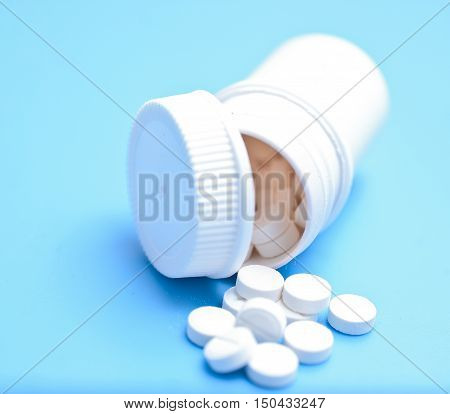 Tablets in botlle on a blue background