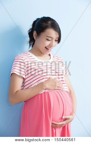 pregnant woman is smile isolated on bluebackground asian