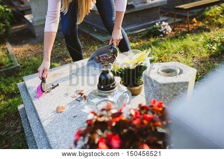 A Woman Cleans The Grave