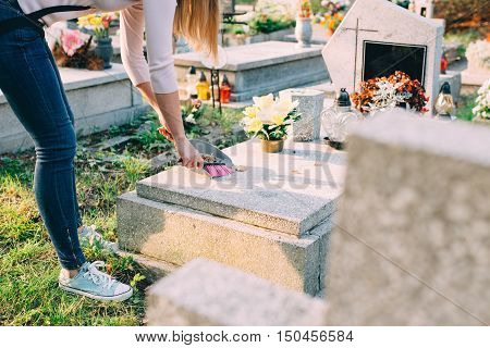 A Woman Cleans The Grave.