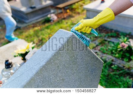 A Woman Cleans The Grave.