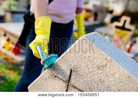 A Woman Cleans The Grave.
