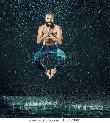 The male break dancer in water on dark background.