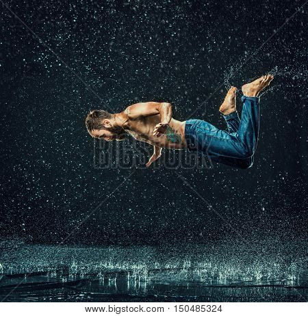 The male break dancer in water on dark background.