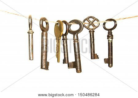 Many keys hanging on a rope on over white