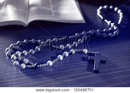 rosary and bible on the wooden table